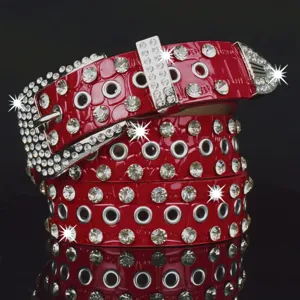Ceinture femme rouge incrustée de strass avec œillets métalliques et boucle brillante vue.