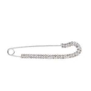 Silver rhinestone safety pin close up detail shot, dazzling crystal design for apparel.