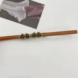 Primer plano de la hebilla de metal rosa bronce en un cinturón de cuero marrón delgado.