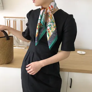 Women's silk square scarf featuring elegant botanical leaf print and stylish green border detail.