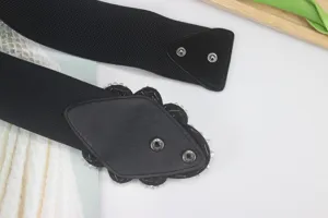 Close-up detail of women's black elastic waist belt with sparkling rhinestone decorative buckle.