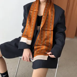 Élégant foulard en soie orange avec imprimé chaîne de luxe et ourlet contrasté femme.