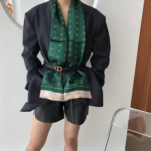 Élégante écharpe longue en soie verte avec imprimé chaîne classique, idéale pour un look.