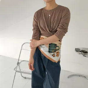 Fashion autumn long sleeve top and silk scarf styling set with casual denim jeans for women.