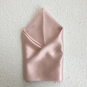 Pure silk square scarf in elegant pink color, beautifully folded for detailed texture showcase.