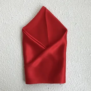 Detailed view of a luxurious red silk square scarf, perfectly folded for elegant gift presentation.