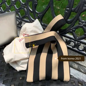 Nahaufnahme einer stilvollen schwarz-beigen gestrickten Handtasche mit feiner Textur.