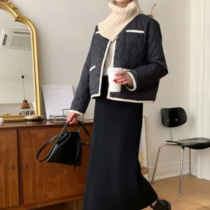 Detailaufnahme des Winteroutfits mit schwarzer Steppjacke, Strick-Rollkragen und Rock.