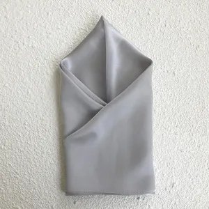 Detailed view of luxury mulberry silk square scarf in elegant light grey with smooth texture.