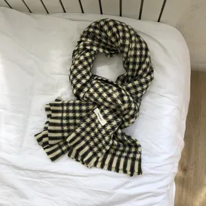 Detailaufnahme eines klassischen karierten Strickschals mit Fransen für den Winter.