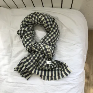 Detailansicht des Schals mit Hahnentrittmuster, Fransen am Saum und weichem Stoff für den Winter.