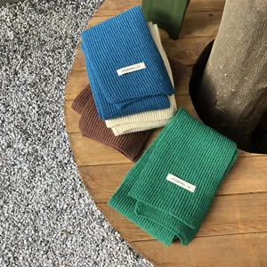 Detailansicht winterlicher Strickschals in mehreren Farben mit feiner Rippstrickstruktur.