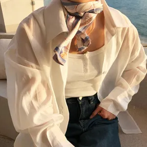 Gros plan d'un foulard en soie étroit à motif floral autour du cou, style élégant.