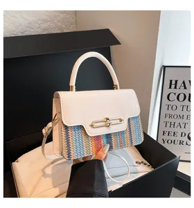 Close-up detail of the stylish spliced shoulder bag featuring a white flap and colorful woven body.