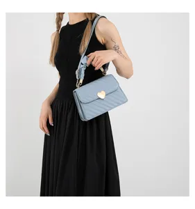 Light blue quilted shoulder bag detail featuring a gold heart lock and scrunchie handle design.