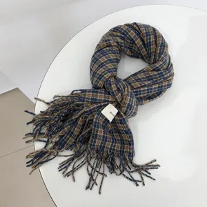 Detailansicht des blau-braunen Karo-Schals mit stilvollen Fransen und feinem Markendetail.