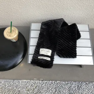 Black plush winter scarf with stylish fabric labels, soft warm fuzzy neck wrap for women.