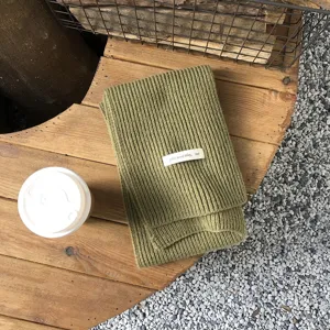 Grüner Damen Winter Strickschal, warmer kuscheliger Grobstrick Schal mit kleinem Etikett.