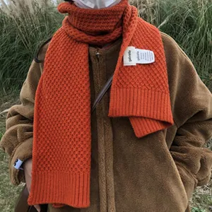Kuscheliger orange Strickschal, dicker warmer Winterschal mit stylischem Stoffetikett.