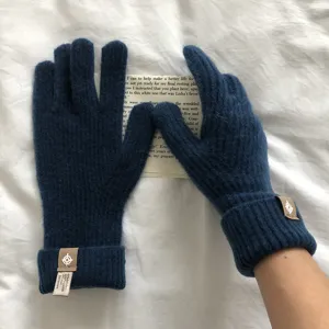 Nahaufnahme der dunkelblauen Strick-Touchscreen-Handschuhe mit feiner Wolltextur und Bündchen.