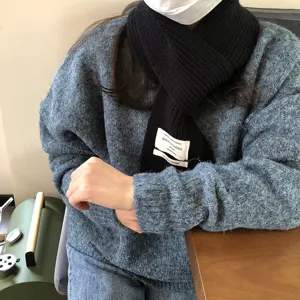 Nahaufnahme eines stilvollen schwarzen Strickschals mit einem schicken Stoffetikett.