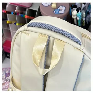 Primo piano dettagliato dello zaino beige con manico superiore in rete traspirante e spallacci.