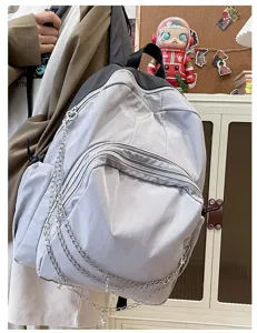Grey casual student backpack with multi-zipper pockets and stylish metal chain charm for daily commute