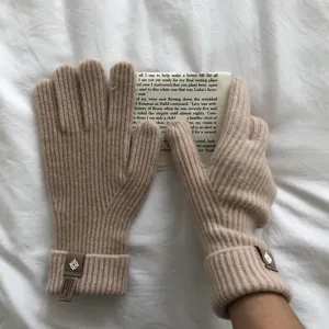 Einfarbige Strickhandschuhe aus Wolle mit Touchscreen-Funktion und Lederetikett für den Winter.