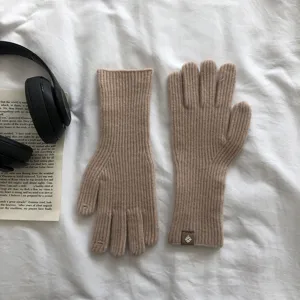 Nahaufnahme von einfarbigen Winter-Strickhandschuhen mit Touchscreen in Kamel, Wollmaterial.