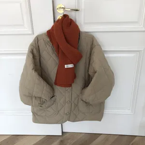 Vue détaillée d'écharpe en tricot uni, combinée avec une veste matelassée, accessoire d'hiver.