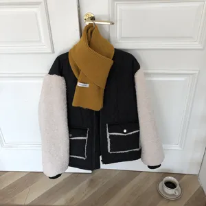 Écharpe en tricot uni et veste à manches contrastées en détail pour un style d'hiver confortable.
