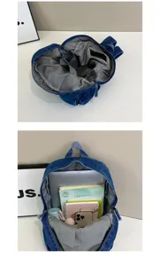 Denim backpack interior detail showing large capacity, multiple compartments, and student daily use.