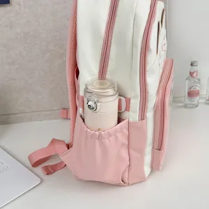 Süßer rosa-weißer Schüler-Rucksack mit seitlicher Flaschentasche, Detailansicht.