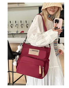 Bolso bandolera de lona burdeos para estudiantes, bolsa informal diaria con múltiples bolsillos.