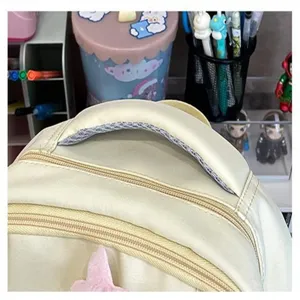 Primo piano del manico dello zaino casual beige e della doppia cerniera, cuciture resistenti.