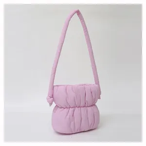 Vista detallada del bolso de hombro acolchado de nailon rosa, diseño de bolso saco plisado.