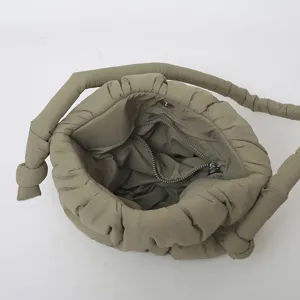 Detalle de bolso de hombro de nailon acolchado, bolso saco suave abullonado con tirantes nudos.