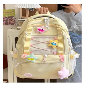 Vista dettagliata dello zaino giallo multitasche con simpatici ciondoli a stella di peluche.
