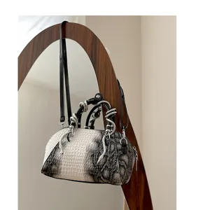 Bolso cruzado con motivo de cocodrilo retro y asas de serpiente de metal únicas.
