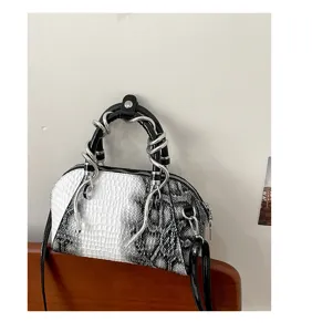 Vista de cerca y detallada del elegante bolso de mano con motivo de cocodrillo.
