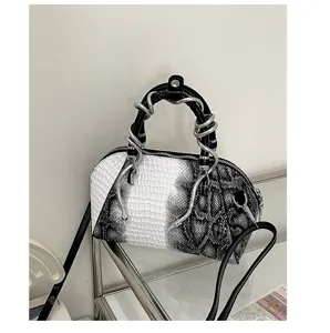 Bolso de mano con diseño de cocodrilo en blanco y negro con asas de serpiente de metal.