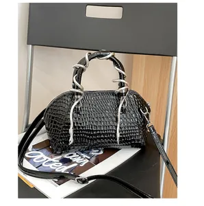 Bolso de mano de concha de cocodrilo charol negro con asa de serpiente plateada única.