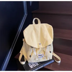 Yellow oxford cloth backpack detail, showcasing the drawstring closure and front label.