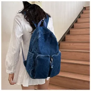 Detailed view of the vintage denim backpack showing front pocket construction and strap design.