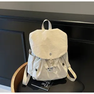 Detail shot of the casual beige oxford cloth backpack showing front flap pocket and strap.