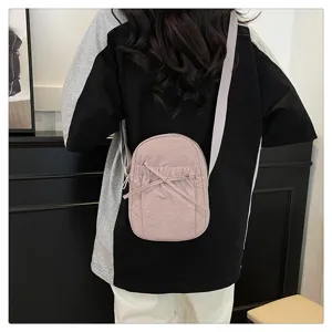 Detailed view of the pink nylon mini crossbody bag with cute bow and pleated design.