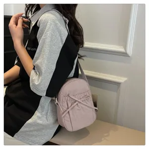 Detailed view of the pink nylon crossbody bag, casual lifestyle nylon purse with cute bow.