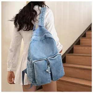 Detail view of stylish vintage denim backpack with multiple pockets and comfortable straps.