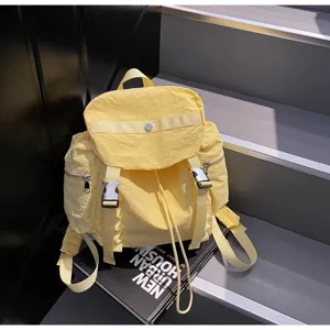 Yellow nylon backpack detail showing durable straps, buckle closure and waterproof fabric.