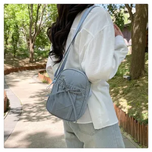 Detailed view of the cute light blue nylon crossbody bag featuring a lovely bow design.